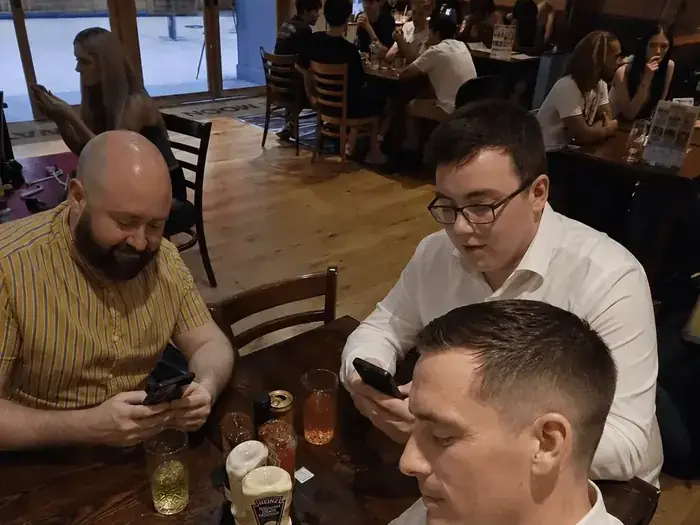 Hombres en un bar mirando el celular